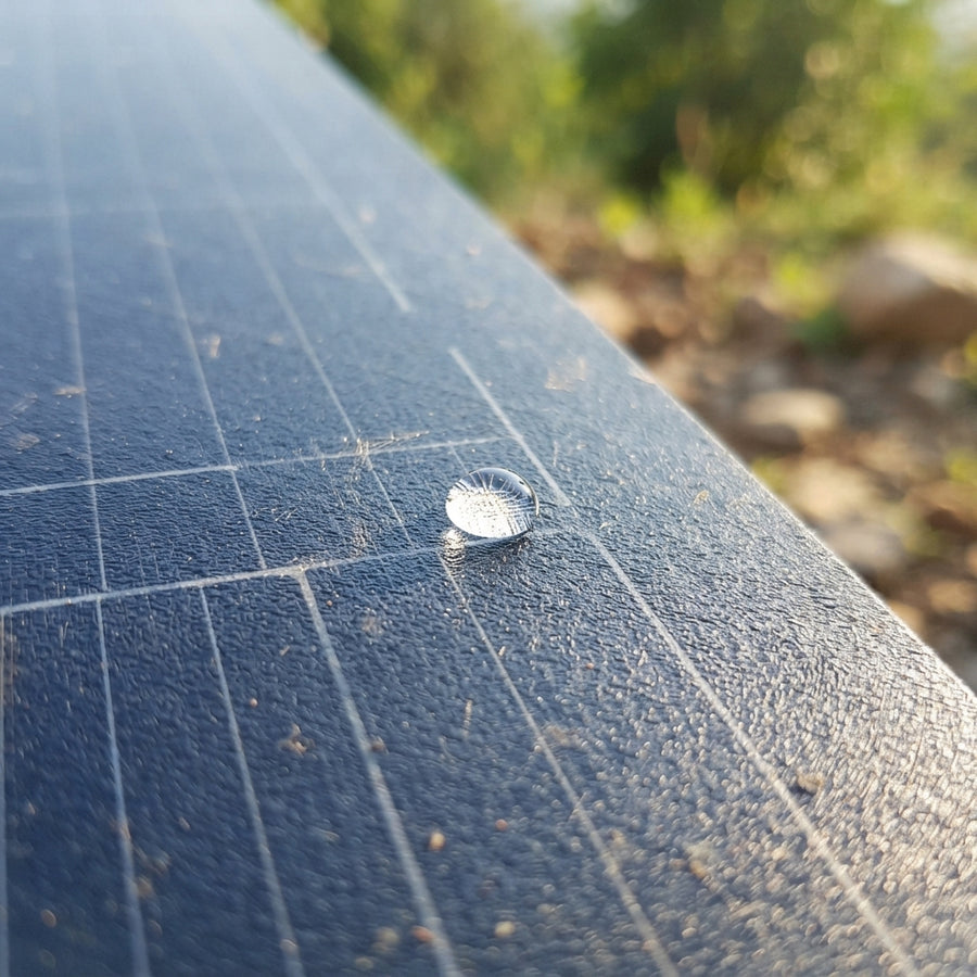 Close-up of a durable ETFE-coated solar panel surface with a water droplet, showing high-grade material texture.